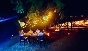 KakumbiMsandile River Lodge的一群人晚上坐在餐桌旁