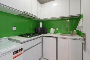布加勒斯特Stone Gate Apartment #1的绿色白色的厨房配有炉灶和水槽