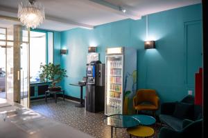 里昂诺曼底酒店的一间设有蓝色墙壁和冰箱的客房