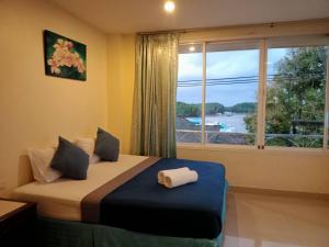 甲米镇Marina Seaview Krabi的一间卧室设有一张床和一个美景窗户。