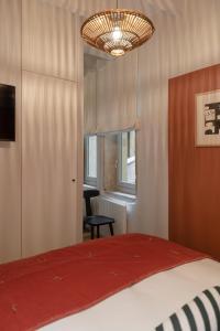 里昂MiHotel Saint Jean的一间卧室配有一张床、一把椅子和一个吊灯。