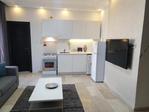 安曼Deir Ghbar-Studio的小厨房配有白色冰箱和桌子