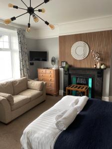 阿伯里斯特威斯Bodalwyn Guest House的一间卧室配有一张床、一张沙发和一个壁炉
