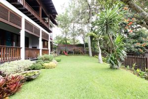 万隆Rumah Pelita near Lembang FREE WIFI - Villa Lantera的一座带绿草和游乐场的房屋的院子