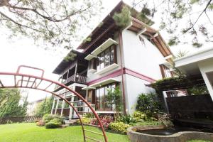 万隆Rumah Pelita near Lembang FREE WIFI - Villa Lantera的前面有游乐场的房子
