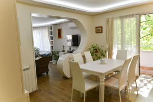 扬博尔Аристократичен апартамент в сърцето на Ямбол的一间配备有白色桌椅的用餐室