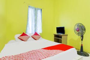 名古屋SPOT ON 91879 Emes Jaya Homestay的一间卧室配有一张带风扇和窗户的床。
