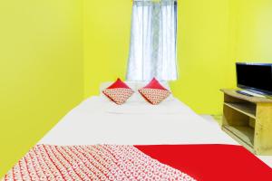 名古屋SPOT ON 91879 Emes Jaya Homestay的一间卧室配有一张带两个枕头的床