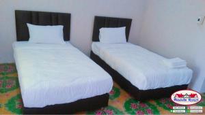 Ban Nong Tumอวบอิ๋มรีสอร์ท #ที่พักภูกระดึง的两张睡床彼此相邻,位于一个房间里