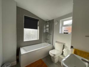 LincolnshireWindmill View Apartments的带浴缸、卫生间和盥洗盆的浴室