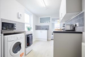 大雅茅斯homely - Great Yarmouth Beach Apartments的白色的厨房配有洗衣机和烘干机