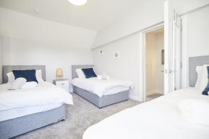 大雅茅斯homely - Great Yarmouth Beach Apartments的一间卧室设有两张床和窗户。