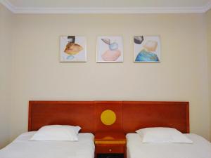 布达佩斯银河酒店的卧室配有两张床,墙上挂有四张照片
