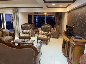 塞得港شقه مطله علي قناة السويس والبحر فيو رائع 702 بورسعيد的客厅配有家具和电视。