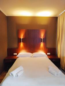 布达佩斯银河酒店的一间卧室配有一张大床,上面有两条白色毛巾