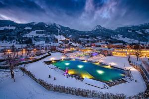 巴特霍夫加施泰因Apartment NH96 inklusive kostenfreiem Eintritt in die Alpentherme的雪地中带游泳池的度假村