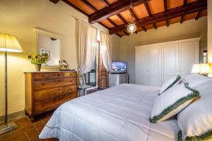瓦尔的圣卡西亚诺安德烈亚别墅 的卧室配有一张白色大床和电视。