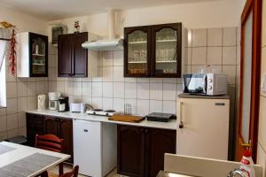 艾斯特根Luca Apartman的厨房配有棕色橱柜和白色冰箱