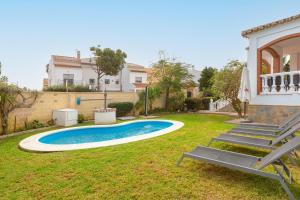 马拉加Casa Guadalmar的一个带游泳池和房子的后院