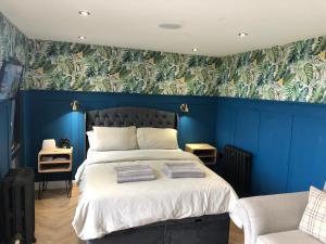 斯旺西The Rhossili bay secret的一间卧室设有蓝色的墙壁和一张带毛巾的床。