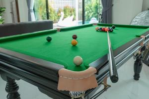 武里南Bonita Pool Villa的一张带线索和球的斯诺克台球桌