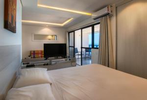 福塔莱萨Particular Iracema Residence的一间卧室配有一张床和一台平面电视