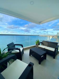 卡塔赫纳Cartagena Palmetto Beach Bella Vista的阳台配有桌椅,享有水景。