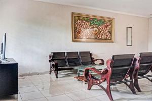 当格浪OYO 91849 Karawaci Taman Permata 5的客厅配有椅子和墙上的绘画