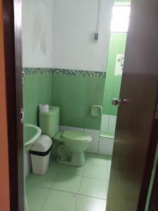 利马华琦公寓式酒店的绿色浴室设有卫生间和水槽