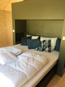 卡兰茨奥赫Tiny House in het groen, aan zee met privé Hottub的一间卧室配有一张大床和大床头板