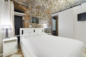 贝加莫BERGAMO art的卧室配有白色的床和石墙