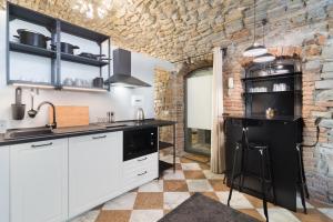 贝加莫BERGAMO art的厨房配有白色橱柜和石墙