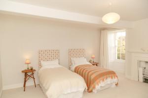 卡迪根Noyadd Trefawr的白色卧室设有两张床,配有壁炉