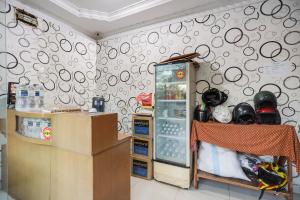 名古屋SPOT ON 91887 Penginapan Rindu的一间设有冰箱和圆圈墙的房间