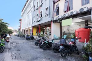 名古屋SPOT ON 91887 Penginapan Rindu的停在建筑物旁边的一排摩托车