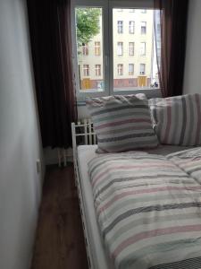 柏林Apartment Berlin Mitte的一张带条纹毯子和窗户的床