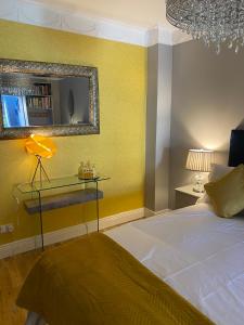 都柏林Beechtree House的黄色卧室,配有床和镜子