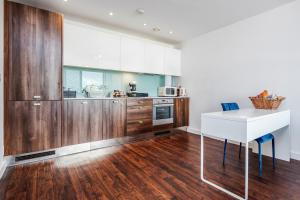 巴塞尔顿2-Bed Apartment Near Basildon Train Station的厨房配有木制橱柜和白色桌子。