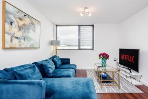 巴塞尔顿2-Bed Apartment Near Basildon Train Station的客厅配有蓝色的沙发和电视