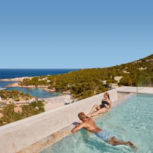 圣安东尼奥TRS Ibiza Hotel -All Inclusive Adults Only的坐在游泳池边的男人和女人
