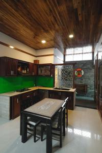 顺化Le Robinet Villa - a journey into Hue citadel soul的厨房配有桌子和绿色的墙壁