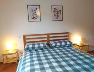 维勒塔巴雷亚Le Masserie Case Vacanza的一间卧室配有一张带两盏灯的蓝色和白色格子床。
