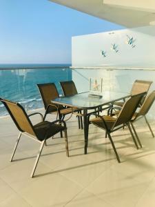 通苏帕Vacaciones Playa Azul的一间设有玻璃桌和椅子的用餐室