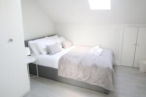 South NorwoodTwelve Thirty Serviced Apartments - 1 Croydon的一间卧室配有一张床,上面有两条毛巾