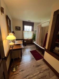 埃尔金斯Upstairs Historic 1 Bedroom 1 Bath Suite with Mini-Kitchen, Porch & River Views的配有床、桌子和灯的房间