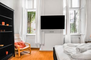 维也纳Chic Apartment - Very Central and Well Connected的客厅配有床和墙上的电视