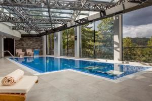克鲁舍沃Panorama Hotel & Spa的一座带大窗户的房屋内的游泳池
