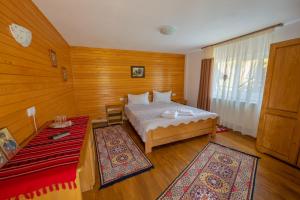 Poiana TeiuluiCabana TYF Dreptu - TYFTRAVEL SRL的一间卧室配有一张床和红色地毯