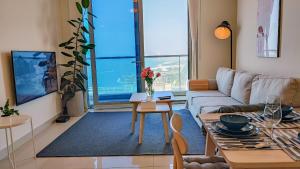 迪拜Exquisite, luxe 1BD Apartment, Unparalleled Sea Views, Prime Dubai Marina Location & Full Kitchen by "La Buena Vida Holiday Homes的客厅配有沙发和桌子
