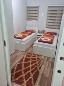 萨拉热窝Apartman Meka的小房间设有两张床,铺着地毯